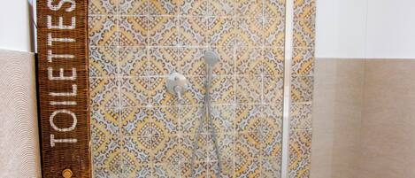 A bathroom with a shower, toilet, and sink.