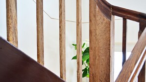 Una escalera de madera con una planta al fondo.