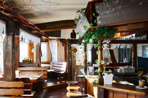 Ein rustikales Interieur mit Holzmöbeln, einer Bar und einer Tafel mit Speisekarte.
