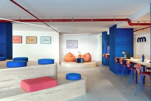 A modern interior with seating areas, a dining space, and artwork on the walls.