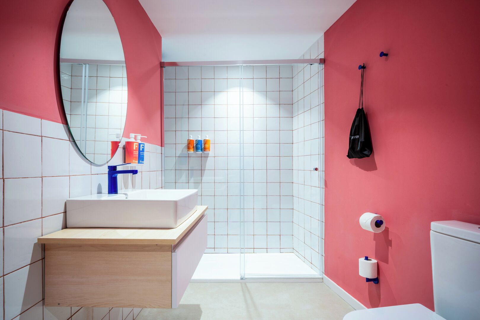 Un baño moderno con lavamanos, espejo y retrete blancos.