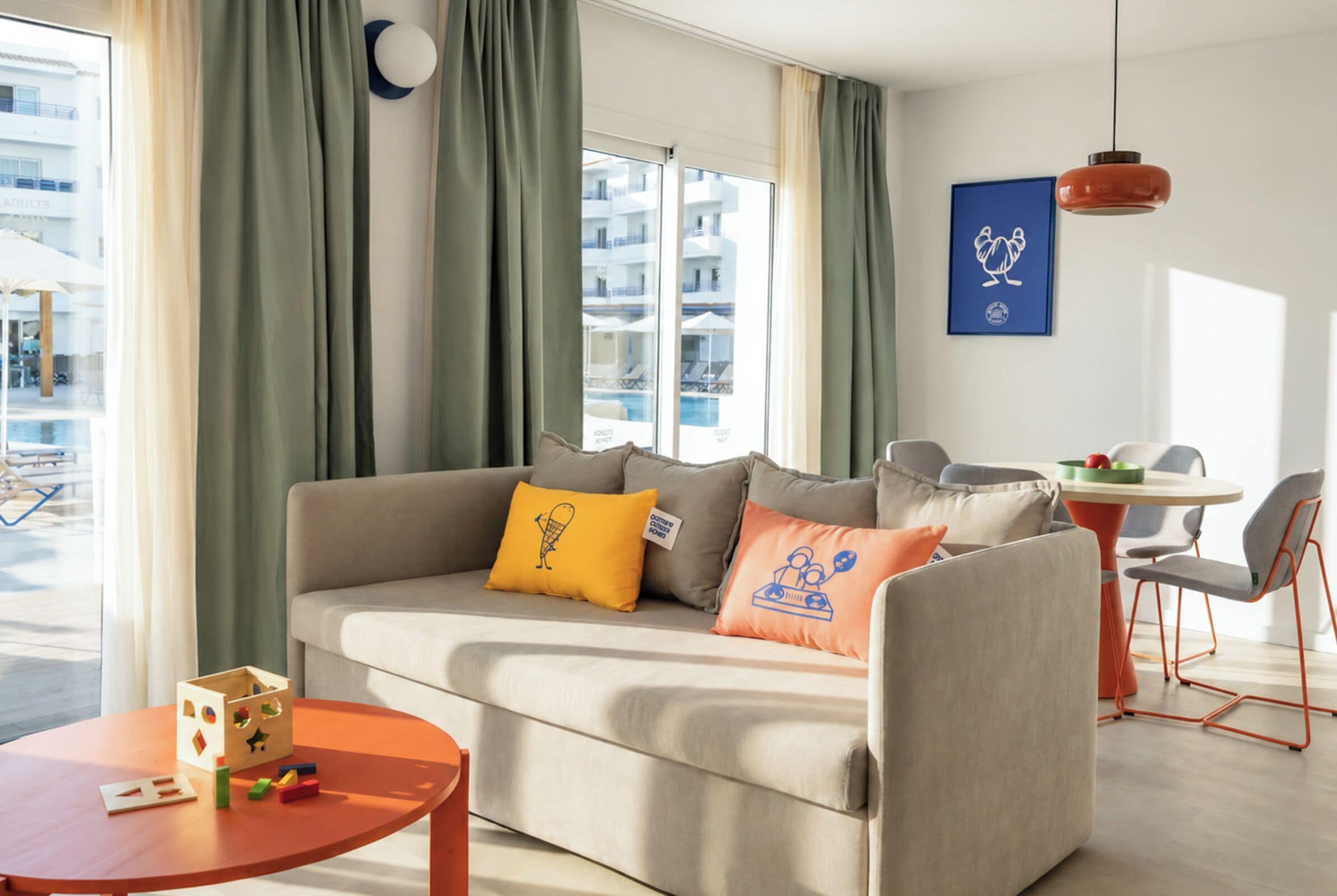 Una sala moderna con un sofá, una mesita de centro y una zona de comedor con sillas y una mesa.