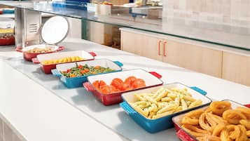Un bufé con diferentes opciones de comida en recipientes.