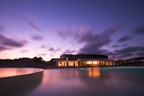 A modern hotel with a pool, reflecting the evening sky. - Mequfi Beach Resort (Mecufi)