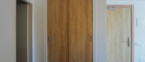 A hallway with a wooden door and a white door.