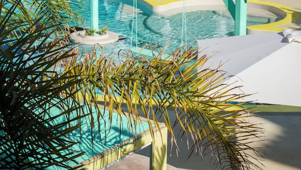 Un espace piscine agrémenté d’une fontaine, de palmiers et de chaises longues.