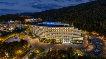 A modern hotel with a circular design, multiple floors, and a parking area.