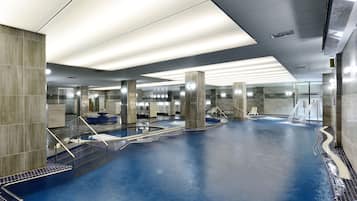 Swimmers can enjoy the pool surrounded by pillars and steps, with a glass partition separating the area.