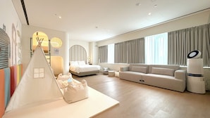 Una habitación de hotel moderna con una cama, un sofá, una estructura parecida a una tienda de campaña y un ventanal grande con cortinas.