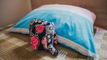 A pillow with a floral pattern and a blue and white striped pillow behind it.