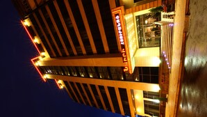 A modern hotel with a prominent 'Hotel' sign, large windows, and a wet ground suggesting recent rain. - New Nairi Hotel (Yerevan)