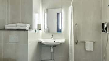 A modern bathroom with a sink, mirror, and shower.