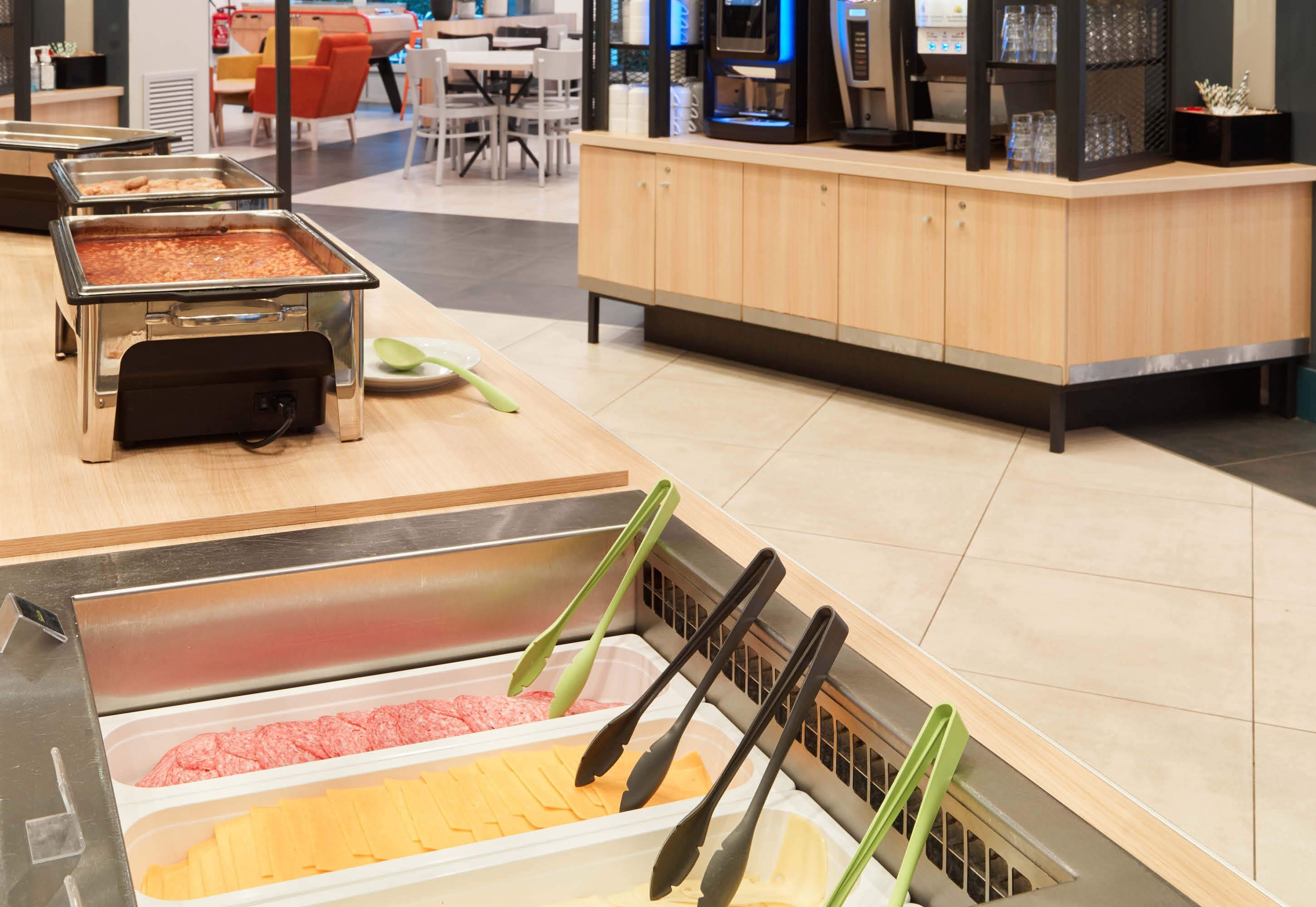 A buffet area with various food options and serving utensils.