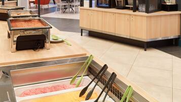 A buffet area with various food options and serving utensils.