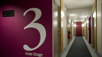 Un pasillo de hotel con un cartel grande con el número '3', que indica las habitaciones 300 a 320.
