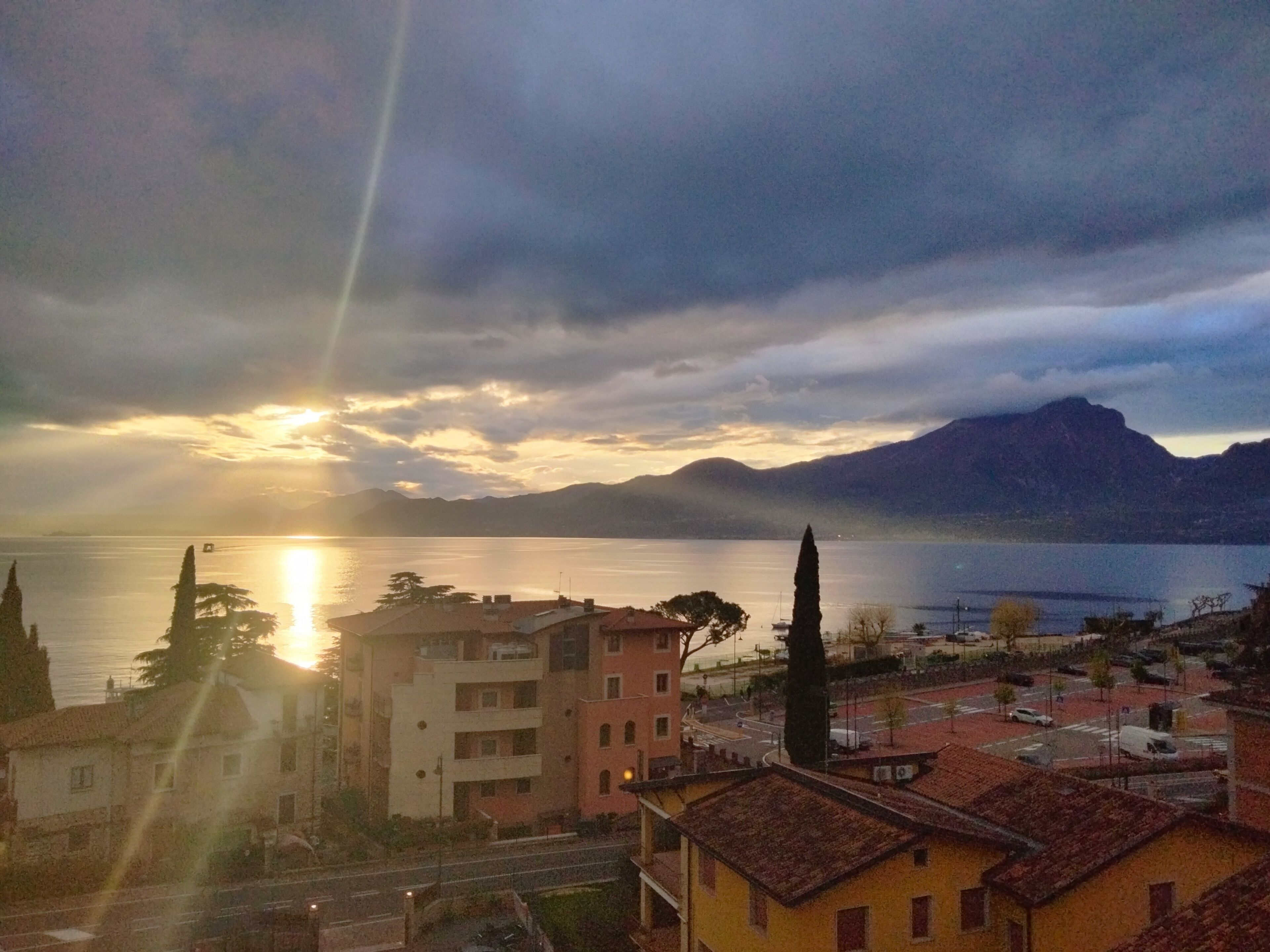 Una cittadina costiera con edifici vicino all'acqua e montagne sullo sfondo.