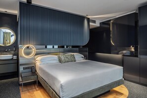 A modern bedroom with a large bed, a round mirror, a bedside table, and a built-in wardrobe. - Hotel Al Caminetto – Adults Only, WorldHotels Crafted (Torri del Benaco)