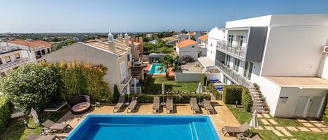 Una piscina al aire libre, sillones reclinables de piscina