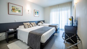 A hotel room with two beds, a desk, a chair, a TV, and artwork on the walls. - Boutique e Villas Boliqueime (Loulé)