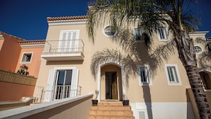 A multi-story building with a balcony, a door, and a palm tree. - Boutique e Villas Boliqueime (Loulé)