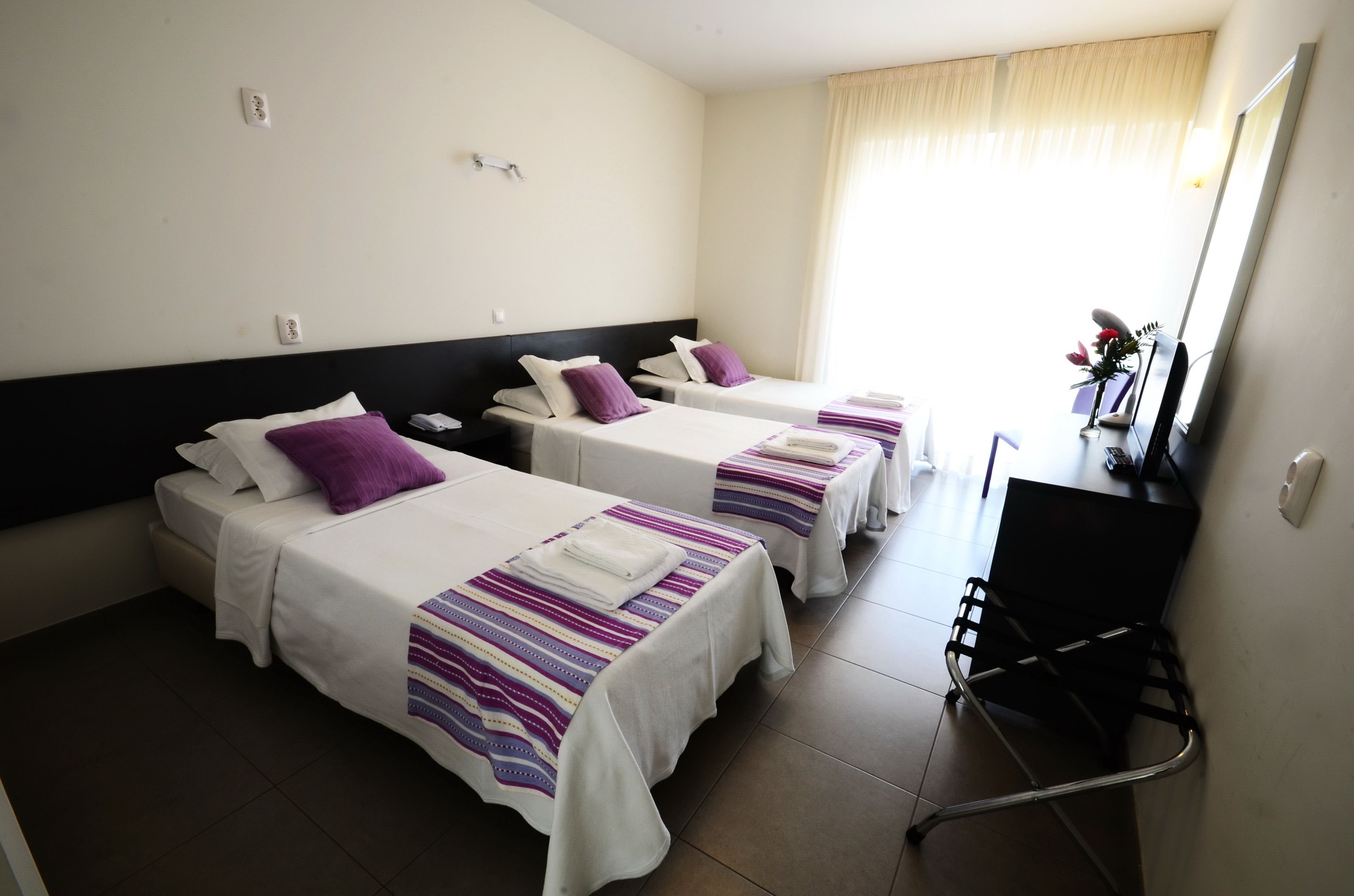 Una habitación de hotel con dos camas, un escritorio y una silla.