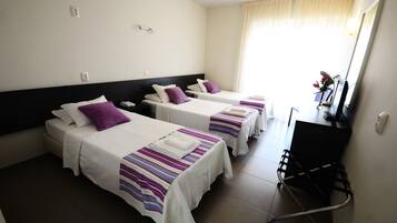 A hotel room with two beds, a desk, and a chair.