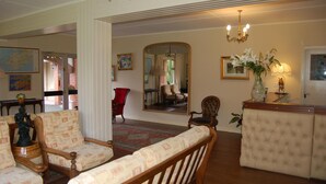 A spacious living room with a large mirror, wooden furniture, and a chandelier. - The Gardens guest accommodation (Killarney)