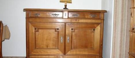 Un mueble de madera con dos puertas y una lámpara encima.