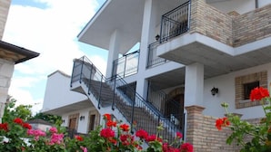 A multi-story building with a central staircase, balconies, and flower boxes. - Il Vecchio Mulino (Chieti)