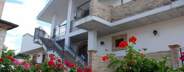 Stunning multi-story building with a grand staircase and lush green surroundings.