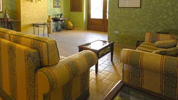 Ein Zimmer mit zwei gelben Sofas, einem kleinen Tisch und einer Nähmaschine.