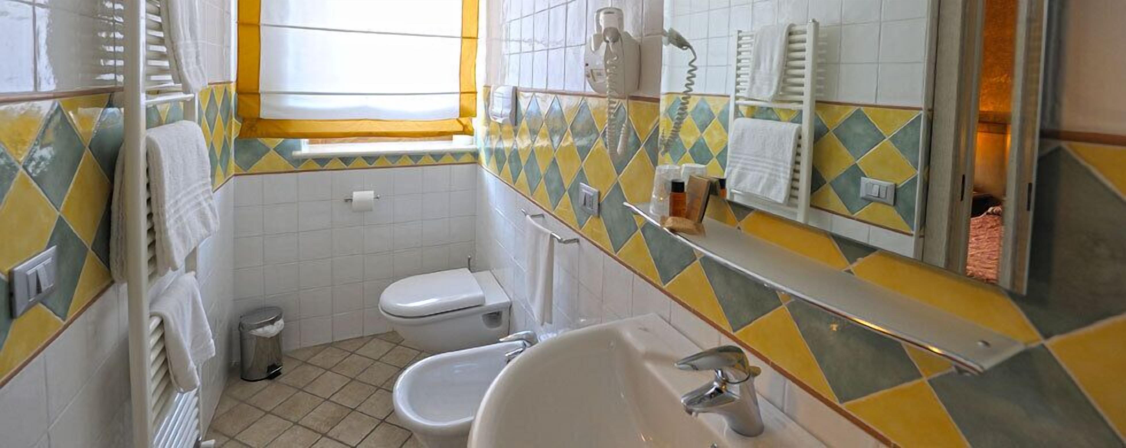 A bathroom with a toilet, bidet, and sink.