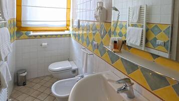 A bathroom with a toilet, bidet, and sink.