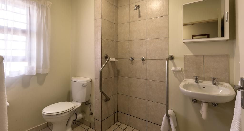 Une salle de bain avec des toilettes, une douche et un lavabo.