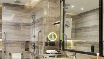 Une salle de bain moderne avec une douche à l’italienne, un meuble-lavabo avec un miroir et un porte-serviettes.
