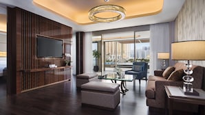 A modern hotel room with a large bed, a TV, a seating area with a glass table, and a balcony with a city view. - JW Marriott Hotel Macau (Cotai)
