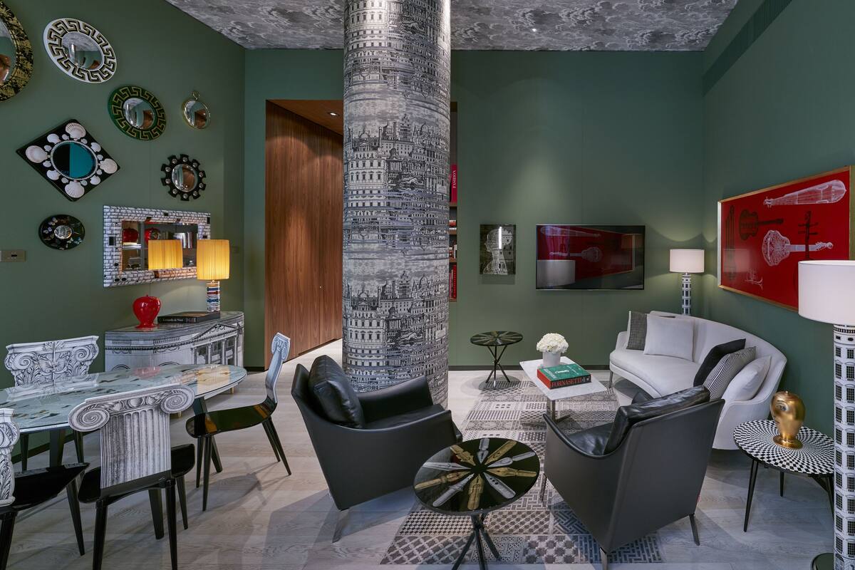 A modern living room with a central column, a dining area with a marble table, and a white sofa.
