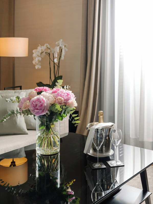 A room with a table featuring a vase of flowers, a champagne bottle, and two glasses. - Mandarin Oriental, Milan (Milan)