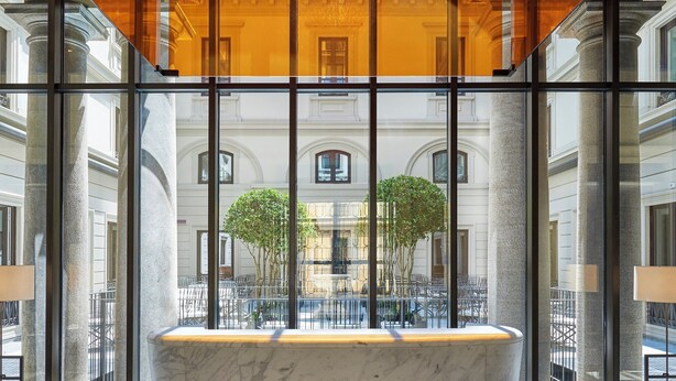 A marble bathtub in a lobby with large windows, checkered floor, and a chandelier. - Mandarin Oriental, Milan (Milan)