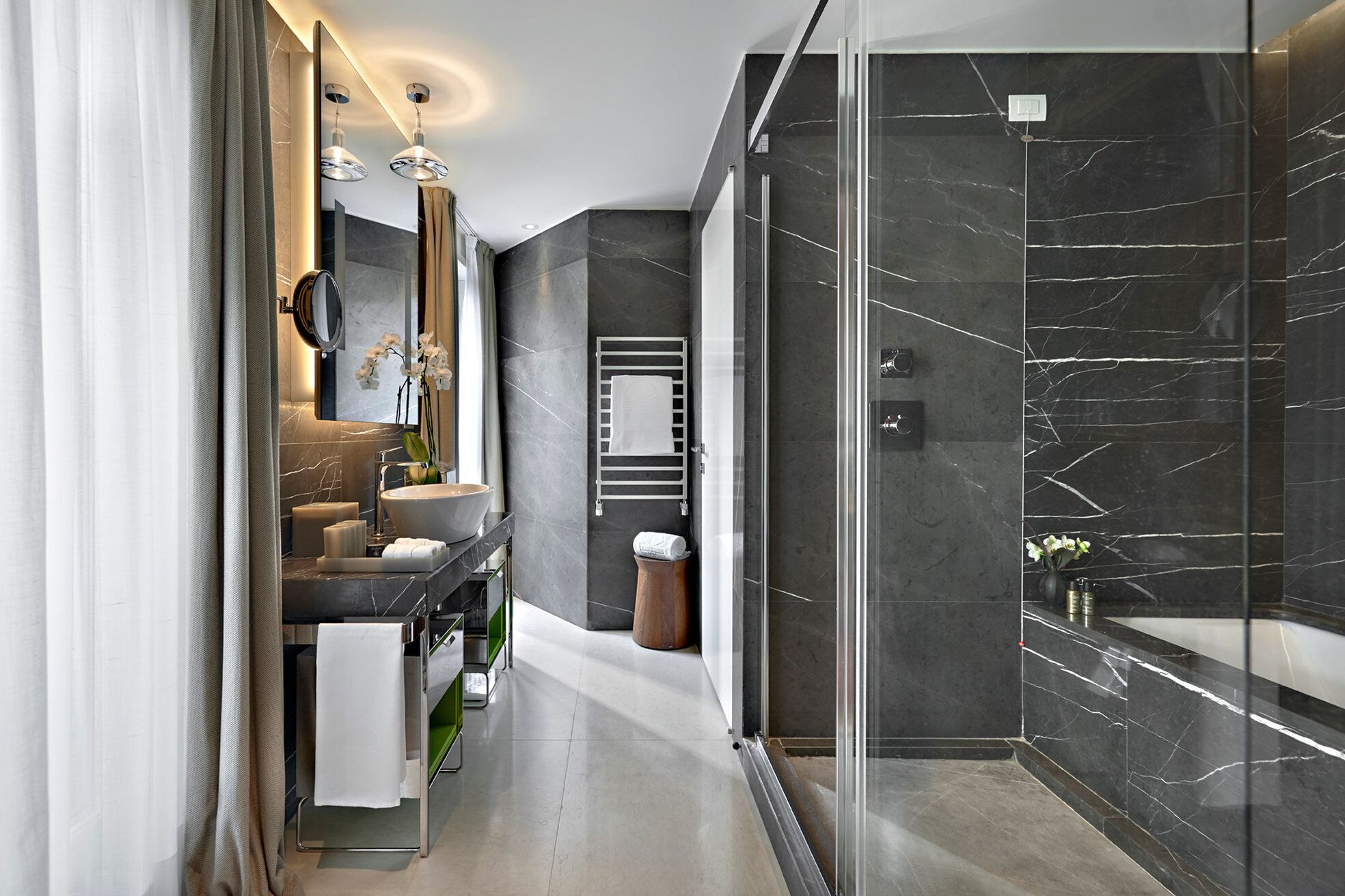 Un bagno moderno con doccia vetrata, uno specchio grande e un mobile lavabo con lavandino e portasciugamani.