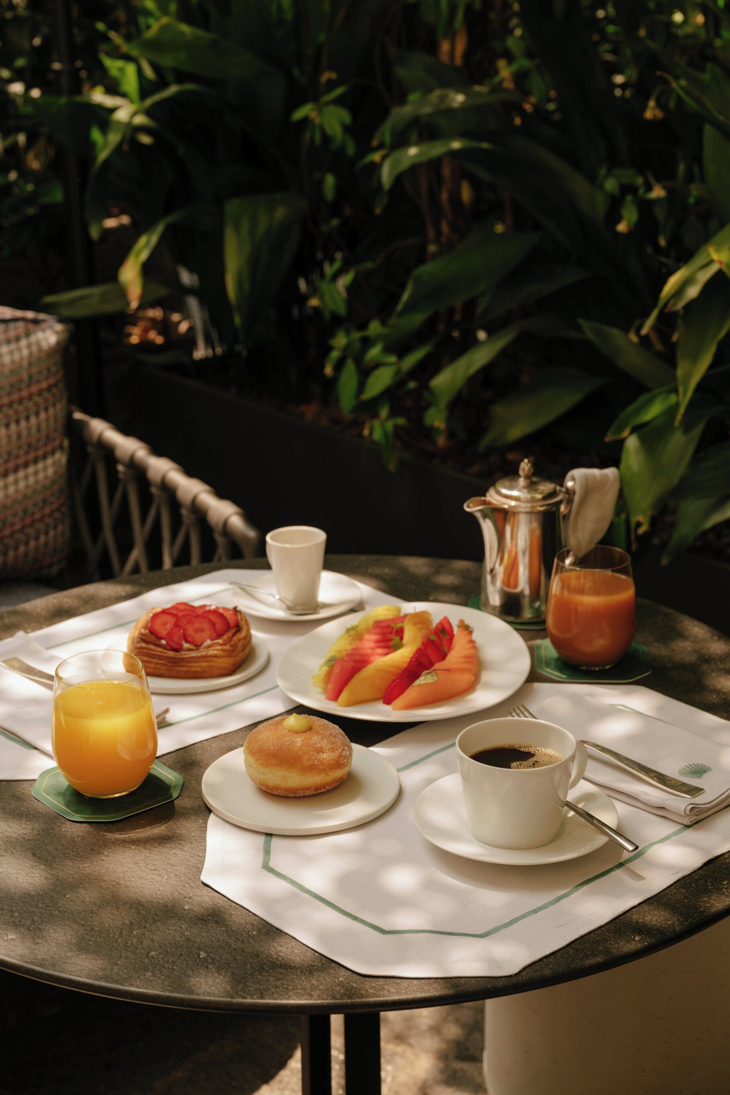 A table with breakfast items including a waffle, toast, a muffin, coffee, and juice.