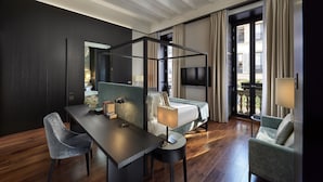 A modern hotel room with a bed, a desk, a chair, a TV, and a balcony with curtains. - Mandarin Oriental, Milan (Milan)