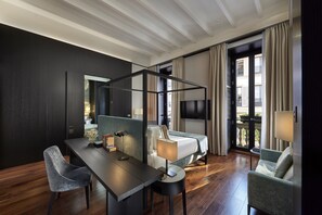 A modern hotel room with a bed, a desk, a chair, a TV, and a balcony with curtains. - Mandarin Oriental, Milan (Milan)