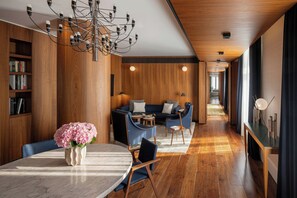 A modern interior with a dining area, a sofa set, and a wooden ceiling.