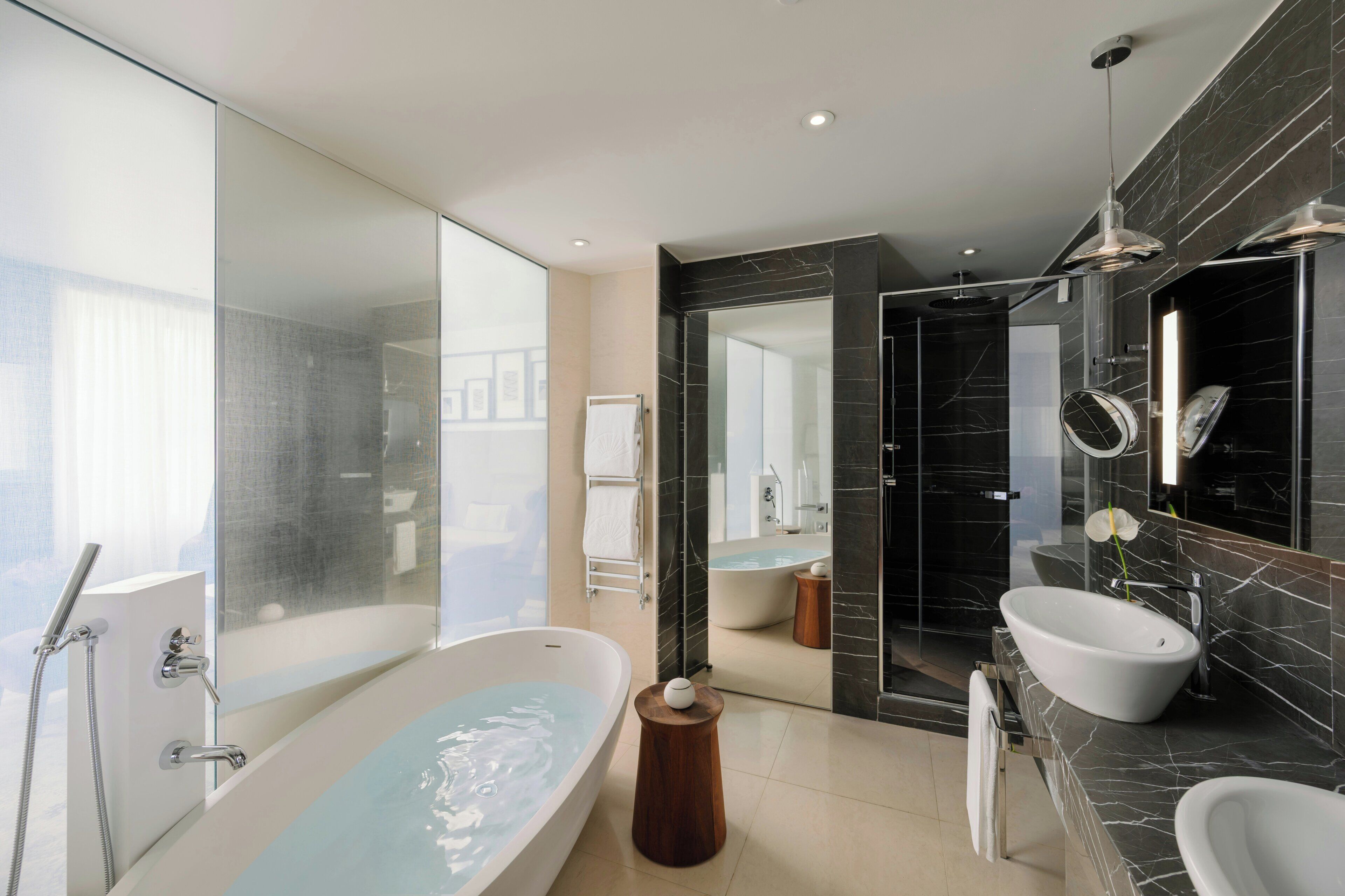 Une salle de bain moderne avec une baignoire sur pieds, un meuble-lavabo et un grand miroir.