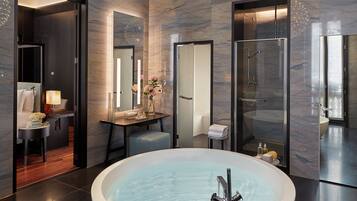 Ein modernes Badezimmer mit einer großzügigen, freistehenden Badewanne, einer gläsernen Dusche und einem dekorativen Kronleuchter.