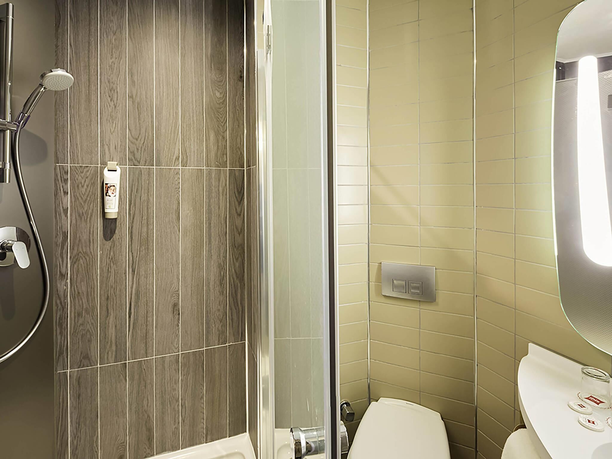 A bathroom with a shower, toilet, and sink.