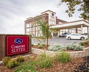 A Comfort Suites hotel with a parking lot and a signboard. - Comfort Suites Woodland - Sacramento Airport (Woodland)