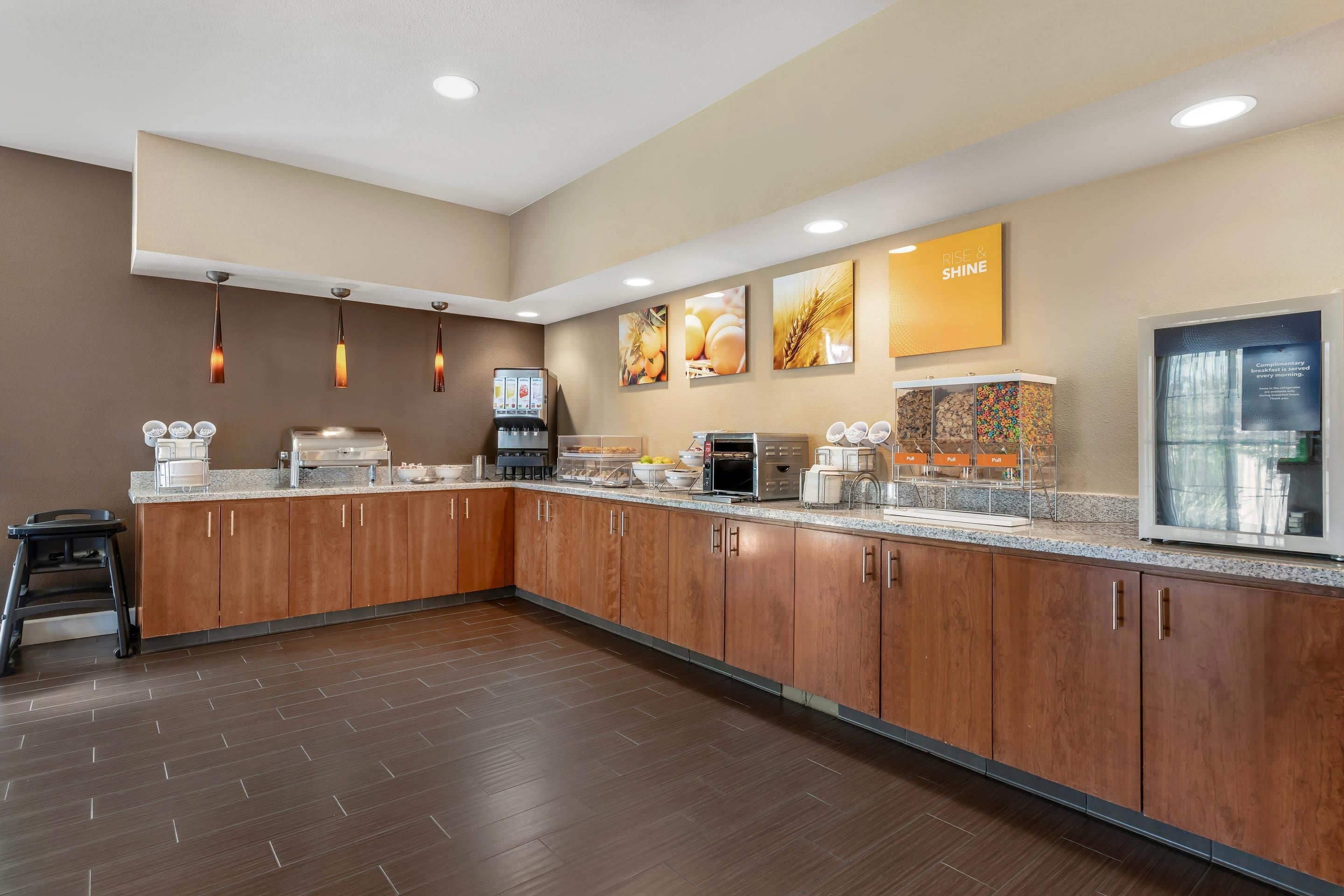 A modern kitchen with a central island, built-in appliances, and a breakfast bar.