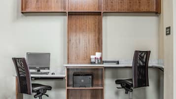A workspace with two office chairs, a desk, a computer, and a printer.